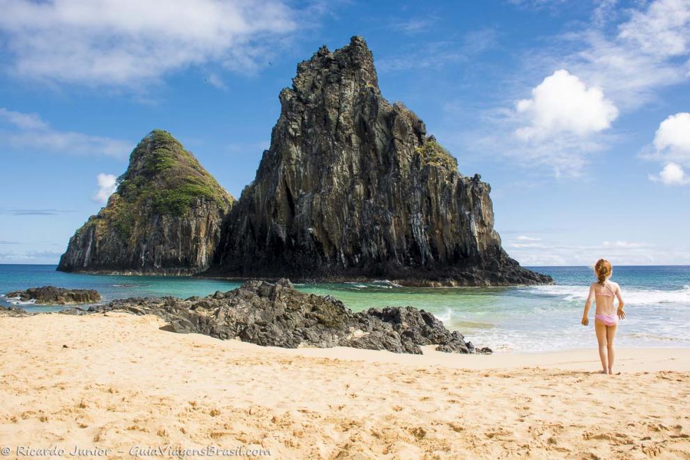 Imagem de uma menina olhando o mar da Praia Cacimba do Padre.